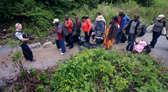 Nigerians seeking asylum in Canada walking from New York border with Canada into the country