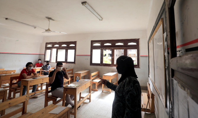 Egyptian high-school pupils, masked and gloved, head into exams